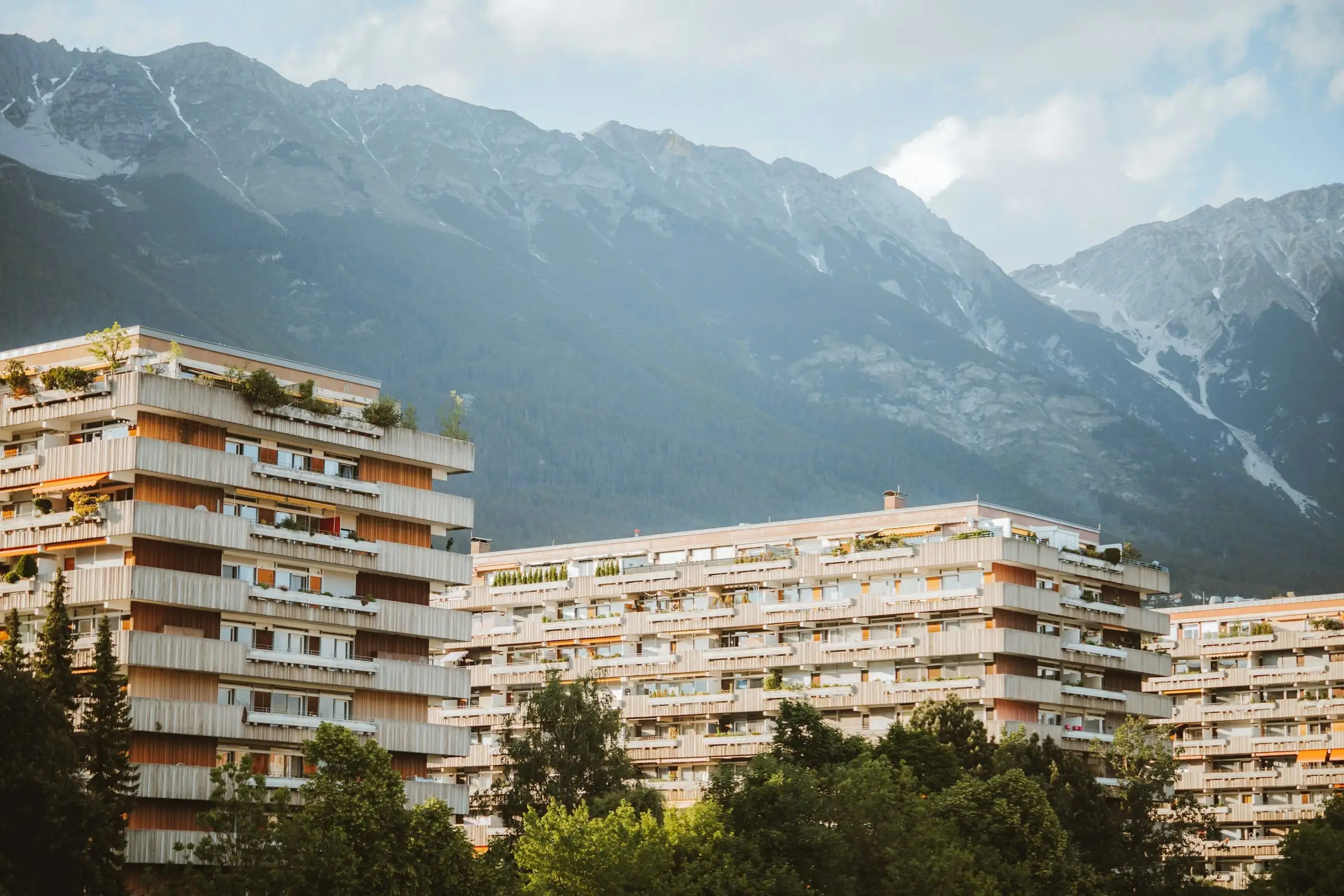 Immeubles locatifs à balcons des années 1970 devant la montagne, façades nettes