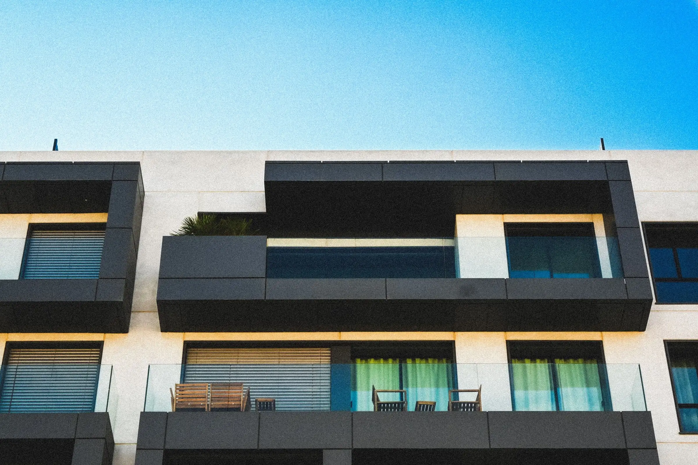 Balcons d’immeuble avec garde-corps en verre et dalles habillées