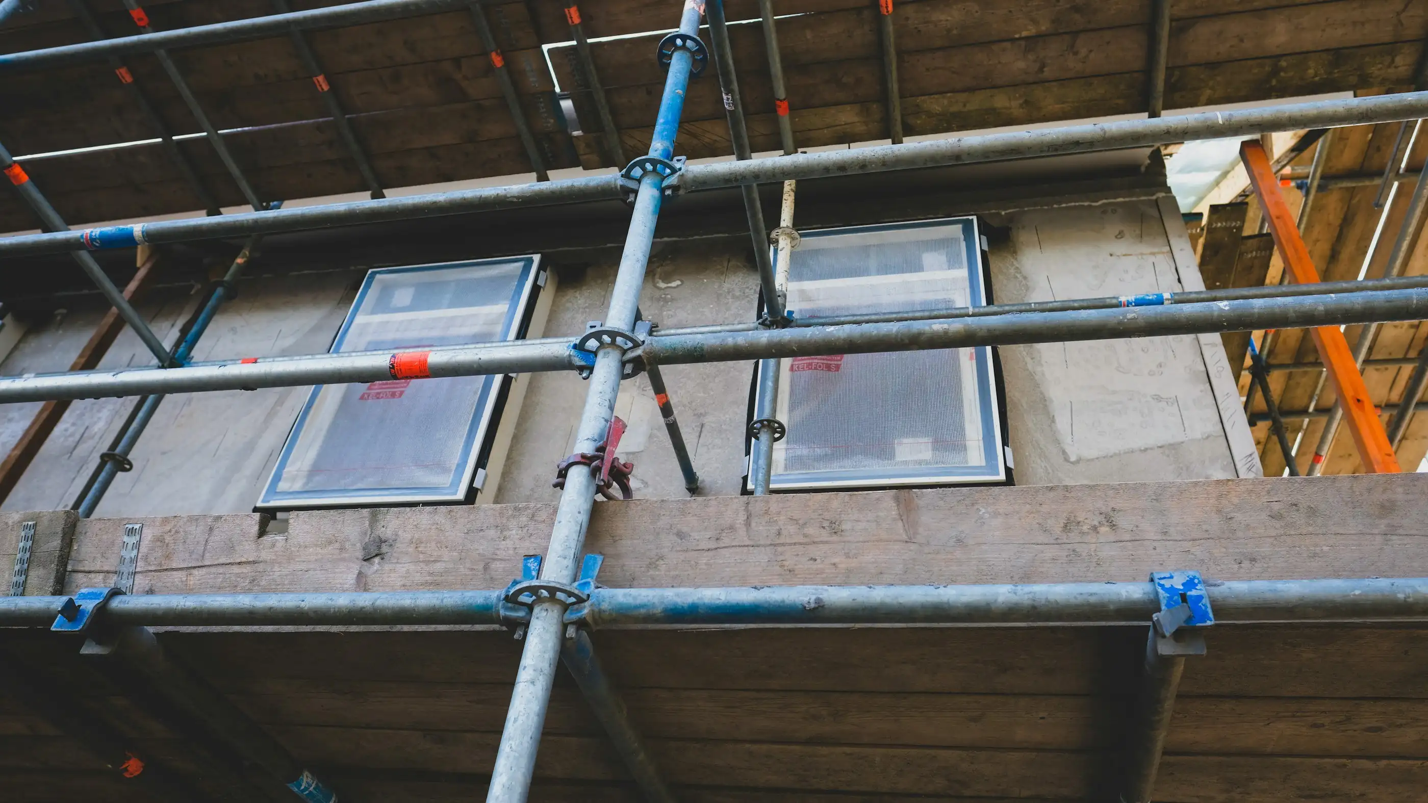 Échafaudage de façade devant des fenêtres neuves, tubes et colliers