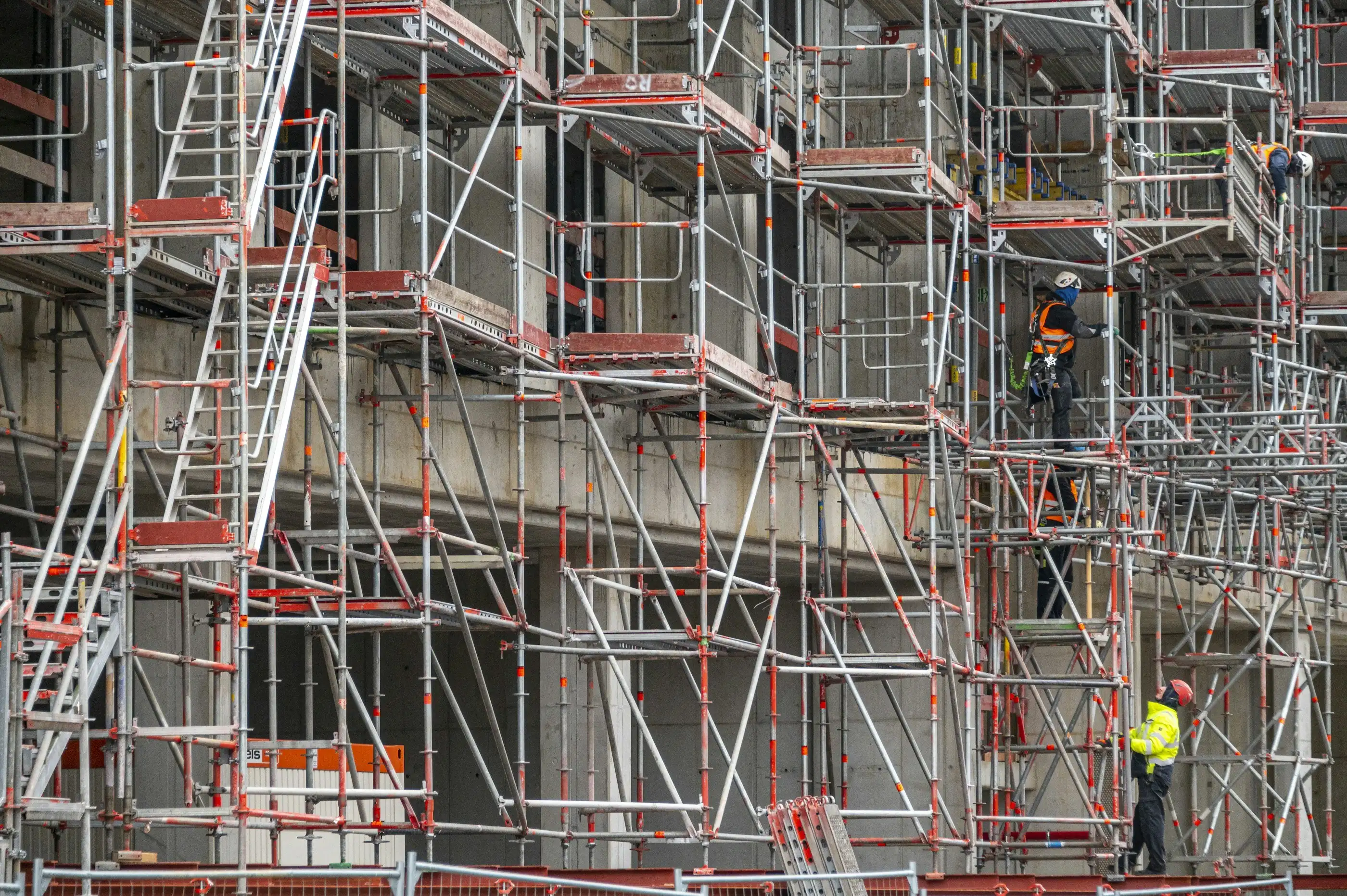 Deux façadiers au travail sur un grand échafaudage d’immeuble